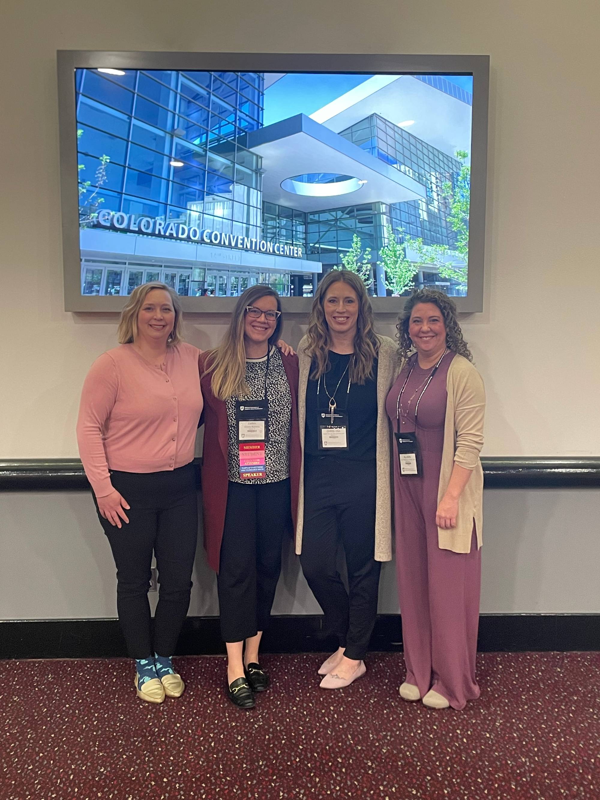 Dr. Quick standing under windows with students